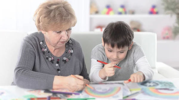 Бабуся і онук малюють веселку в дитячій — стокове фото