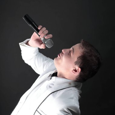 yakışıklı şarkıcı bir song.isolated siyah üzerinde gerçekleştirir.