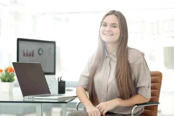 Primo piano della giovane imprenditrice sorridente seduta sul posto di lavoro — Foto Stock