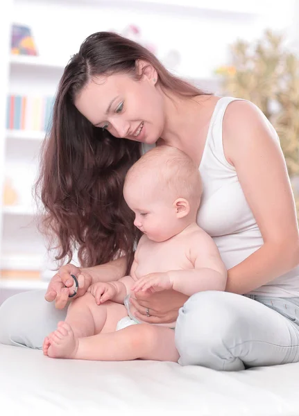 Madre joven enseña al bebé a pararse. el concepto de maternidad — Foto de Stock
