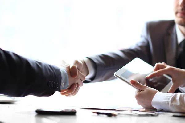 Geschäftsmann mit Tablet-Computer vor dem Hintergrund eines Handschlags von Geschäftspartnern — Stockfoto