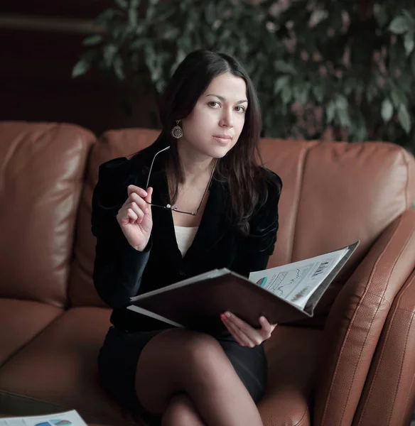 Stäng up.elegant affärskvinna tittar genom finansiella dokument i ett modernt businesscenter — Stockfoto