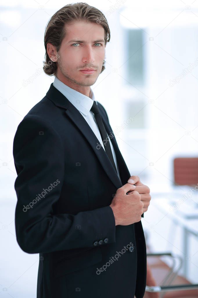 portrait of confident businessman on background of office