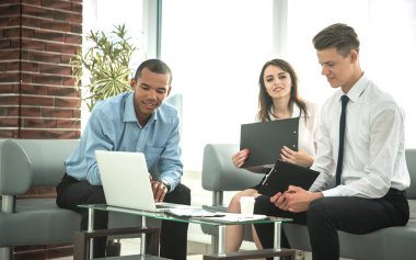 iş takım masa başında otururken laptop arıyor