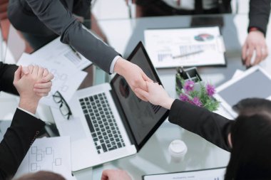 close up. handshake of trading partners at the negotiating table clipart