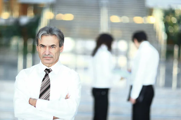 Portrait of a senior businessman on blurred background office — Stock Photo, Image