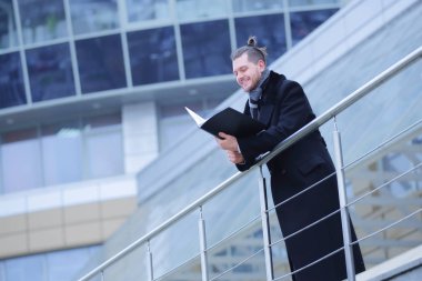 Evrakları olan bir iş adamı, ofisine gelir.