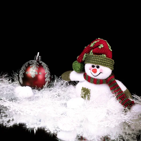 Roztomilý hračka sněhulák na černém pozadí — Stock fotografie