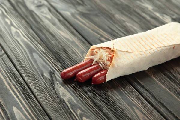 Salchichas de caza en pan de pita sobre un fondo de madera oscura —  Fotos de Stock