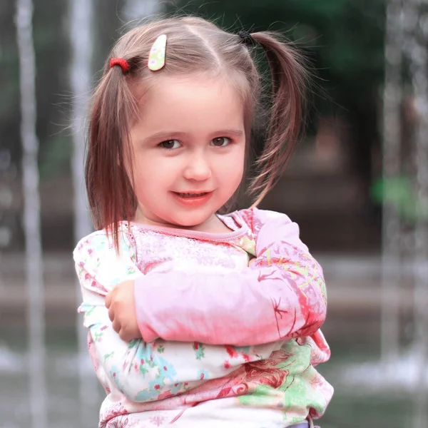 Pretty little girl on the background of the city fountain — Stock Photo, Image