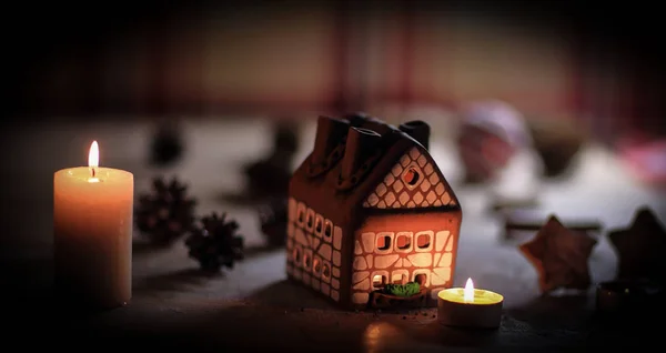 Gingerbread house candle on blurred background of the table. — Stock Photo, Image