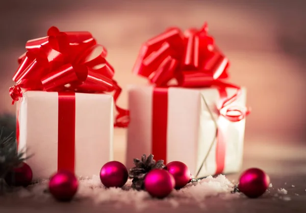 Caja de regalo de Navidad con decoraciones navideñas y conos de nieve. Fondo de madera . — Foto de Stock