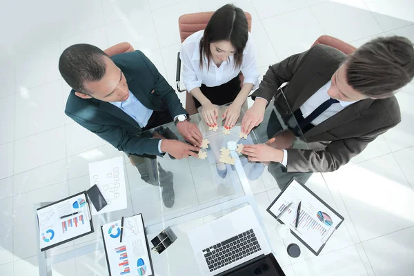 Vista desde la parte superior del equipo de negocios plegable piezas del rompecabezas . — Foto de Stock