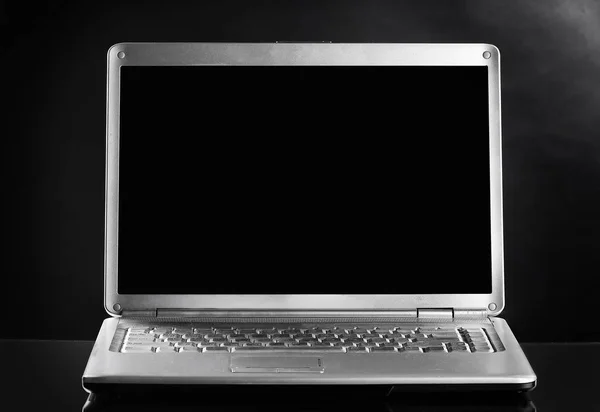 Z bliska. otwarty laptop na ciemnym tle — Zdjęcie stockowe