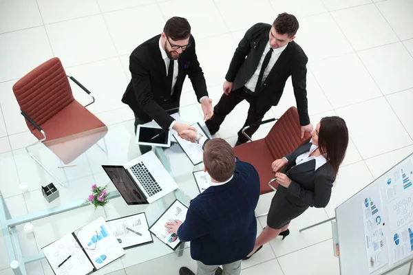 Top view.handshakes z partnerami biznesowymi na biurku — Zdjęcie stockowe
