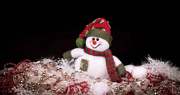 Diversão brinquedo boneco de neve e decorações de Natal em um fundo preto — Fotografia de Stock