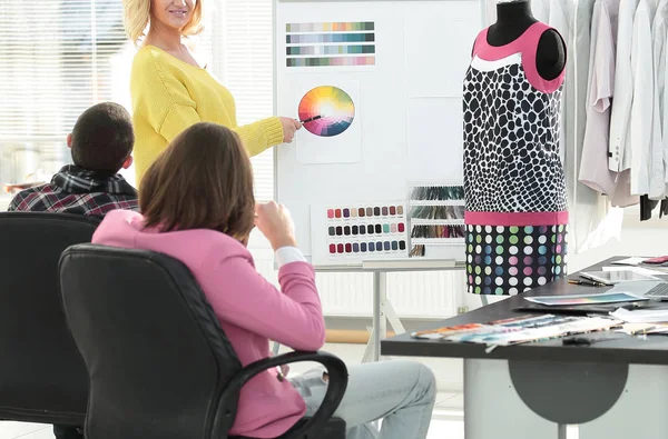 Donna che punta alla tavolozza dei colori swatch mentre discute che colore scegliere con il collega — Foto Stock