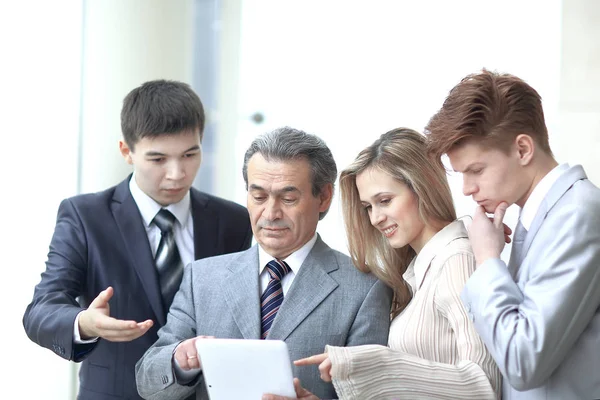 Homme d'affaires et son équipe regardent l'écran de la tablette numérique — Photo