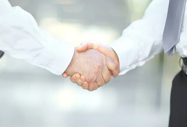 Närbild. handslag för affärspartners på suddig bakgrund. — Stockfoto