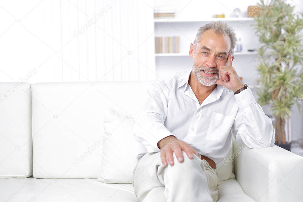 cheerful senior businessman sitting on the couch in the office