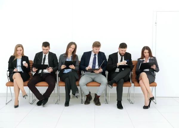 Бизнес-команда с буферами обмена, сидящими в ряд — стоковое фото