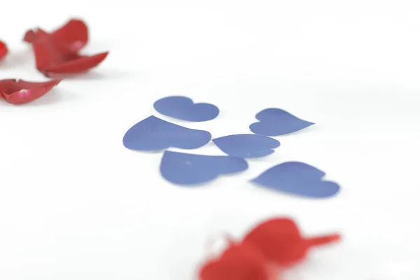 Corazones azules y pétalos rosados sobre fondo blanco.foto con copia — Foto de Stock