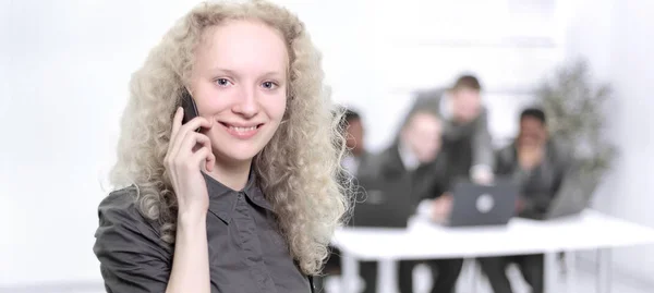 Female assistant talking on mobile phone in office — Stock Photo, Image