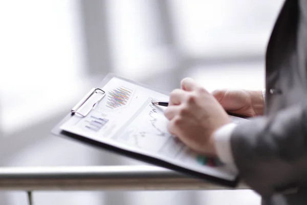 Close up.businessman checking sales schedule.photo on blurred b — Stock Photo, Image