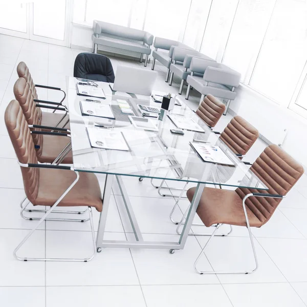 Mesa para negociações com os gráficos financeiros preparados e equipamentos de escritório na sala de conferências antes de reuniões de negócios . — Fotografia de Stock