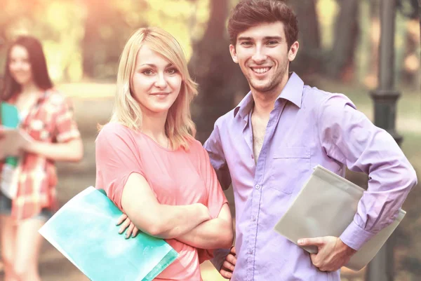 Gruppo di studenti felici con libri nel parco in una giornata di sole . — Foto Stock