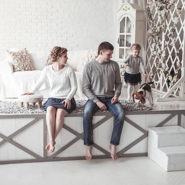 Retrato de una familia feliz y su mascota en un acogedor salón — Foto de Stock