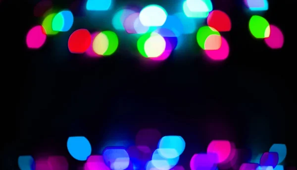 Fondo festivo. luces borrosas sobre un fondo negro — Foto de Stock