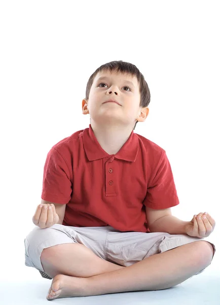 Mały chłopiec siedzi w position.isolated Lotos biały — Zdjęcie stockowe