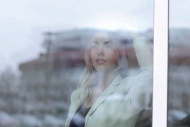 camın arkasından. Ofis pencereden dışarı bakarak Genç iş kadını