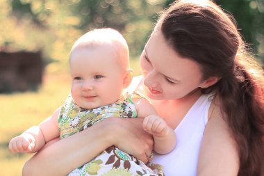 mutlu anne küçük bir kızı onun kollarında tutar.