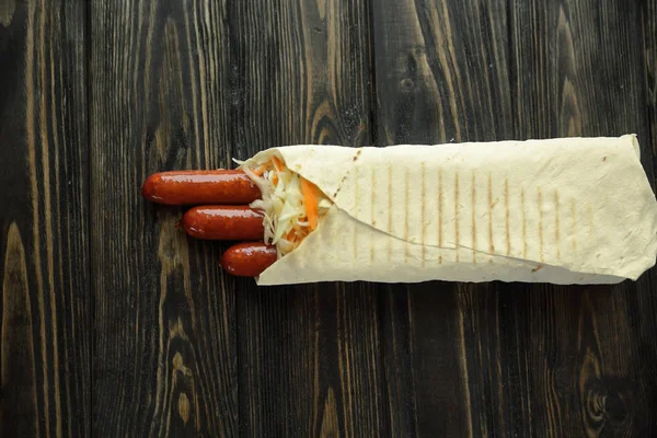 Salchichas en pan de pita sobre fondo de madera.foto con copia spac —  Fotos de Stock