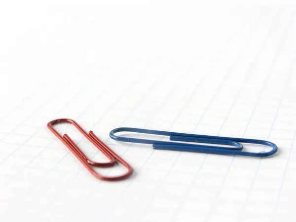 Закрыть голубые и красные скрепки на фоне ноутбука — стоковое фото