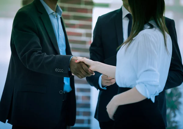 Primer plano .business apretón de manos de los socios financieros en el fondo de la oficina — Foto de Stock