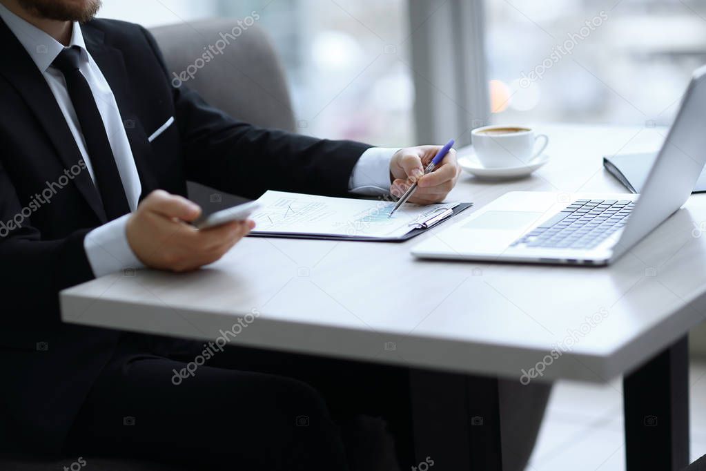 closeup.businessman checking financial statement,sitting at the Desk
