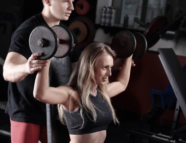 Kişisel antrenör simülatör spor salonunda egzersiz genç kadınla