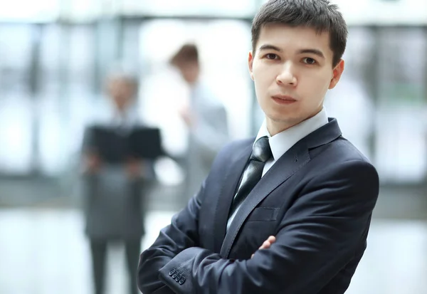 Stäng up.confident ung affärsman på suddig office bakgrund — Stockfoto