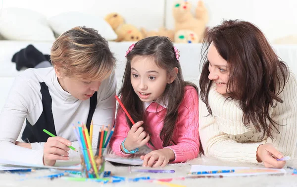 Little girl draws with her mother and grandmother — Stock Photo, Image
