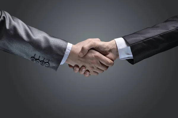 Zavřete up.handshake obchodních partnerů na tmavém pozadí — Stock fotografie