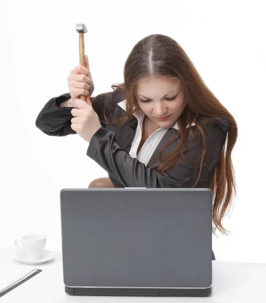 Jonge zakenvrouw probeert te breken de laptop met een hamer — Stockfoto
