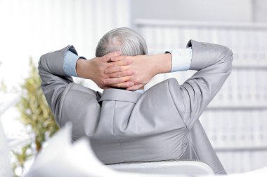 arka view.senior işadamı masasında oturan bir rüya