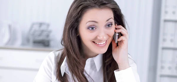 Young business woman talking on mobile phone in office — Stock Photo, Image