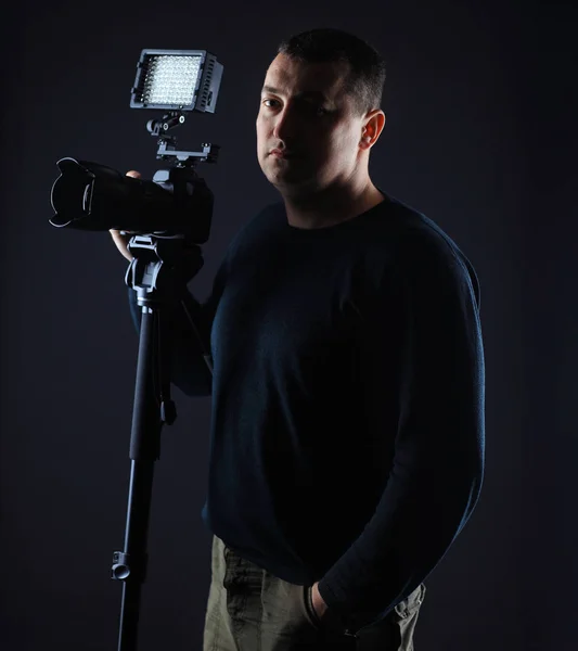 Fotógrafo profissional com uma camera.isolated em fundo preto — Fotografia de Stock