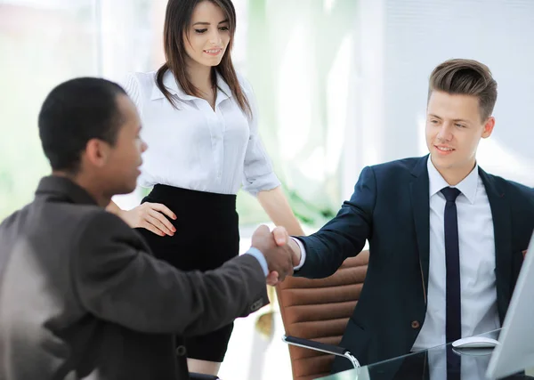 Stretta di mano di partner commerciali seduti a una scrivania — Foto Stock