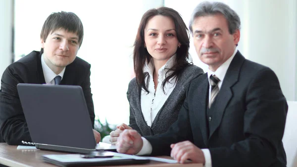 Porträtt av en professionell business-team som sitter bakom ett skrivbord . — Stockfoto