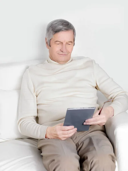 カジュアルな服装でハンサムな老人はデジタル タブレットを使用しています。 — ストック写真